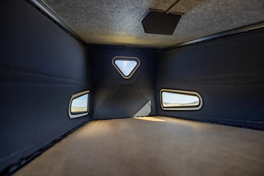 Interior sleeping loft with windows in a modern camper van, perfect for vanlife or overlanding adventures.