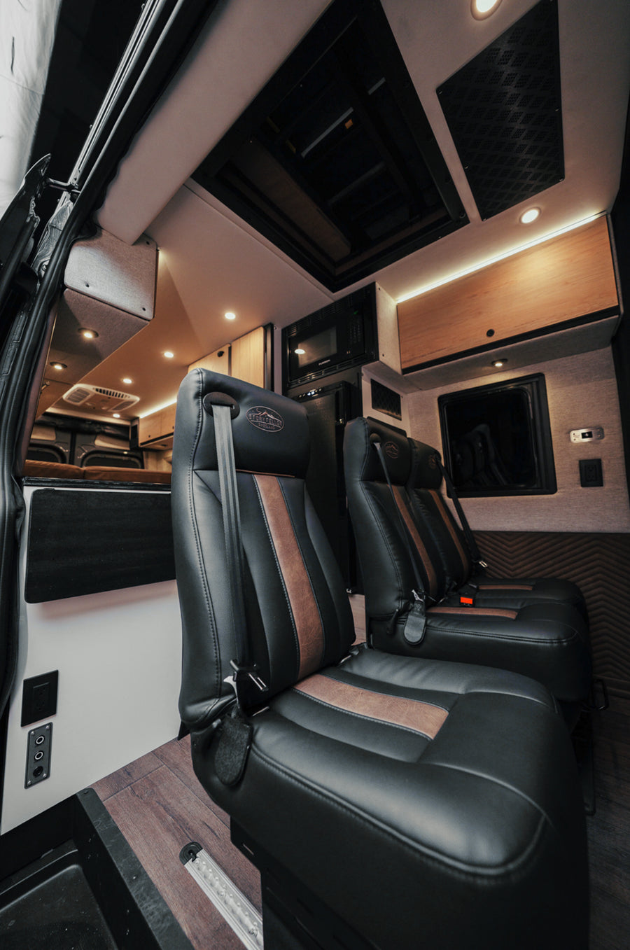 Luxury leather seats inside a modern camper van, adventure van, or Class B RV interior.