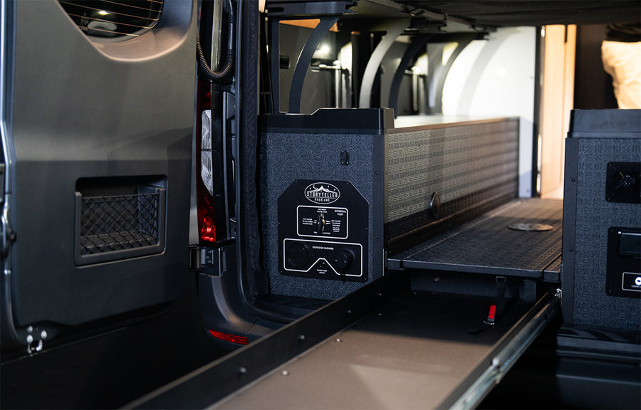 Adventure van trunk interior with gear storage, outdoor shower and custom van conversion features