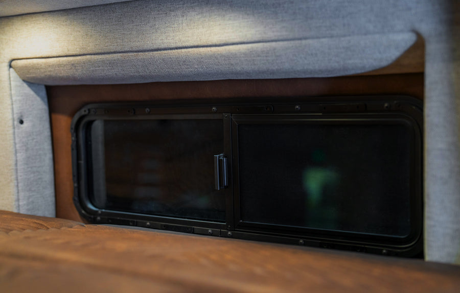 Interior window detail in adventure van campervan conversion with fabric trim and wood paneling