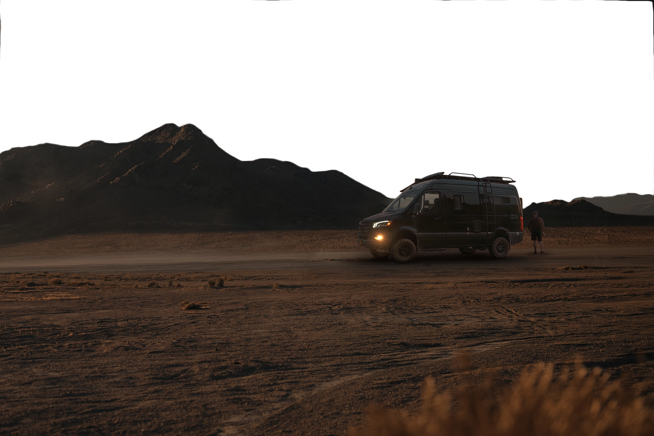 Black 4x4 van parked in desert at sunset, perfect for overlanding and van life adventures.