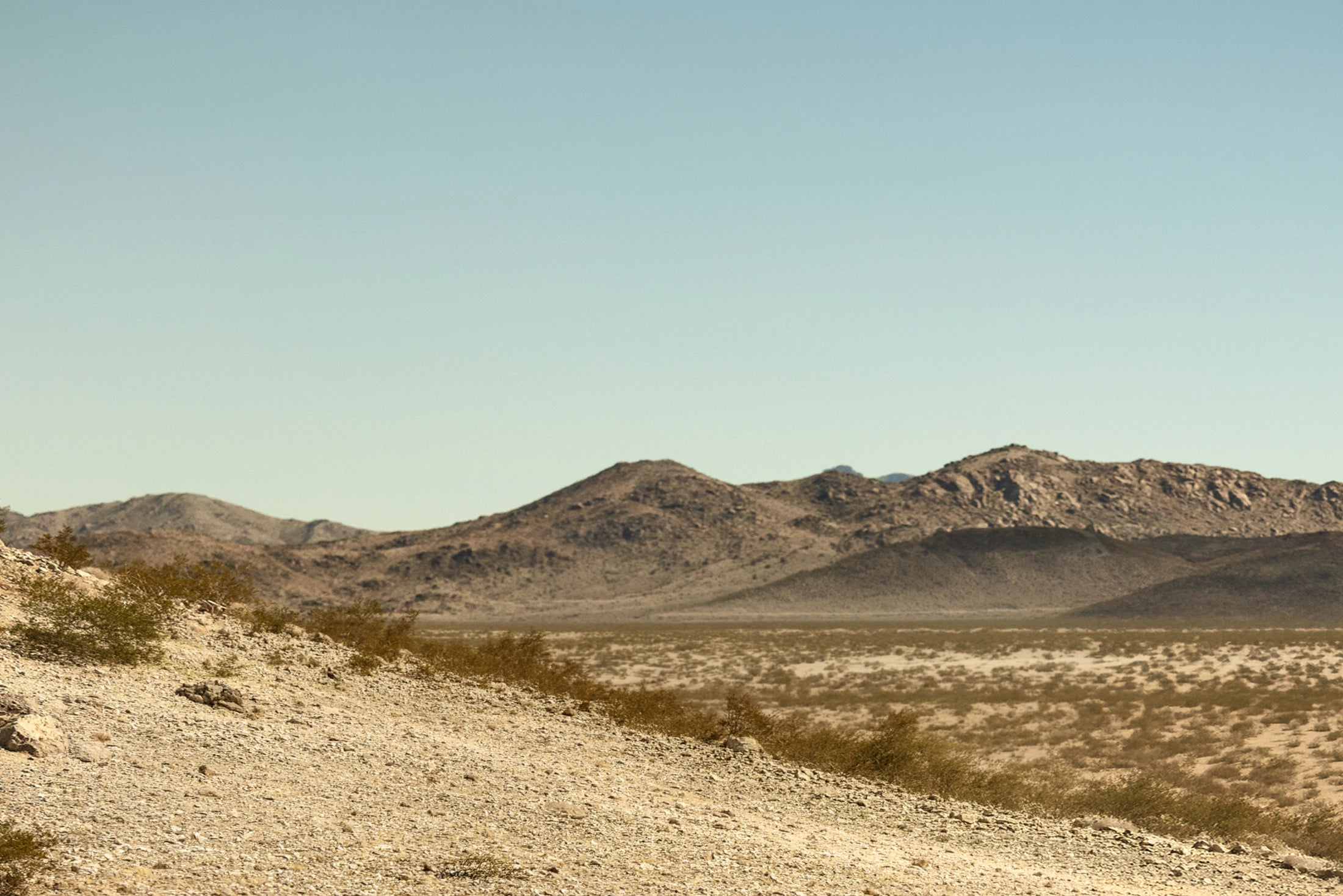 Desert landscape with rugged mountains, ideal for overlanding and adventure travel in a 4x4 van or camper van.