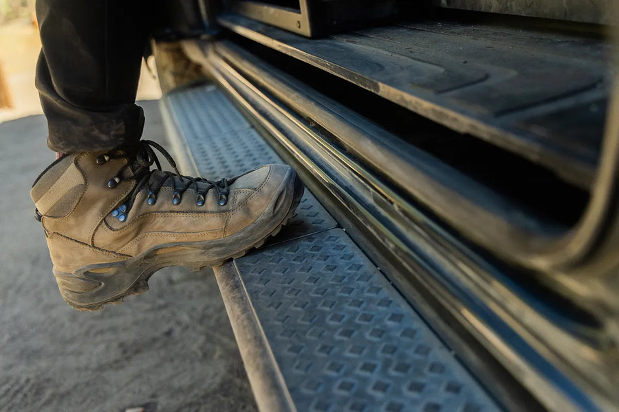 Adventure van step with rugged hiking boot, ready for offroad exploration and vanlife journeys.