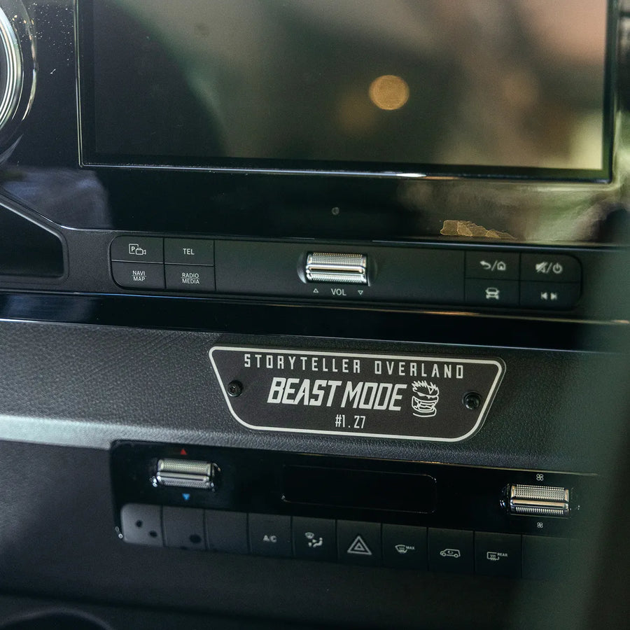 Storyteller Overland Beast MODE #1.27 plaque on custom adventure van dashboard, featuring 4x4 controls and media system.
